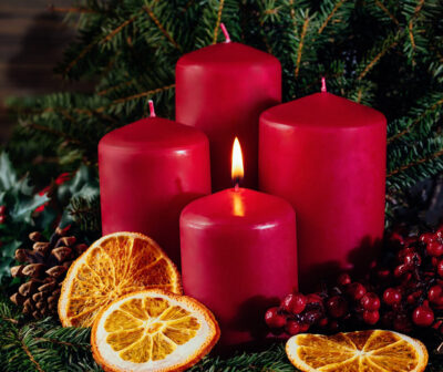 Red candles in advent wreath decoration on wooden dark background Adventskranz aus Nordmanntanne